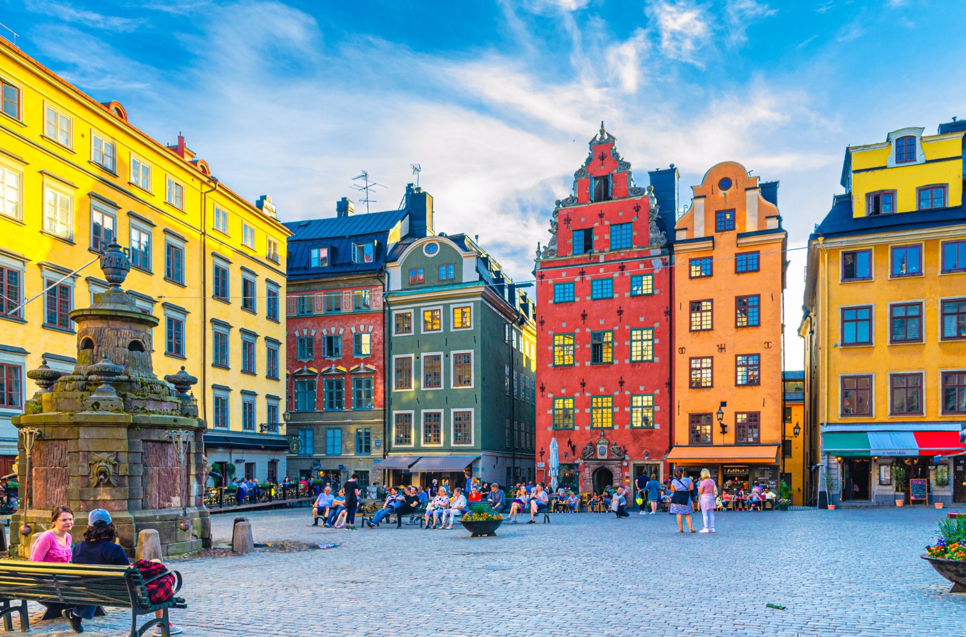 Touristes et passants sur la place Stortorget à Stockholm, entre des maisons colorées